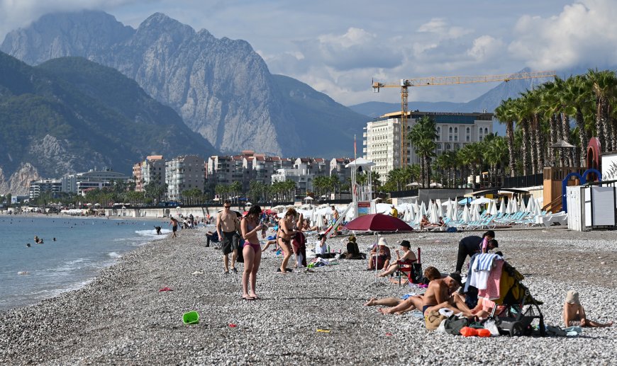 Antalya'da sağanak bitti, Konyaaltı sahili canlandı! Köpeği Atom ile denize girdi