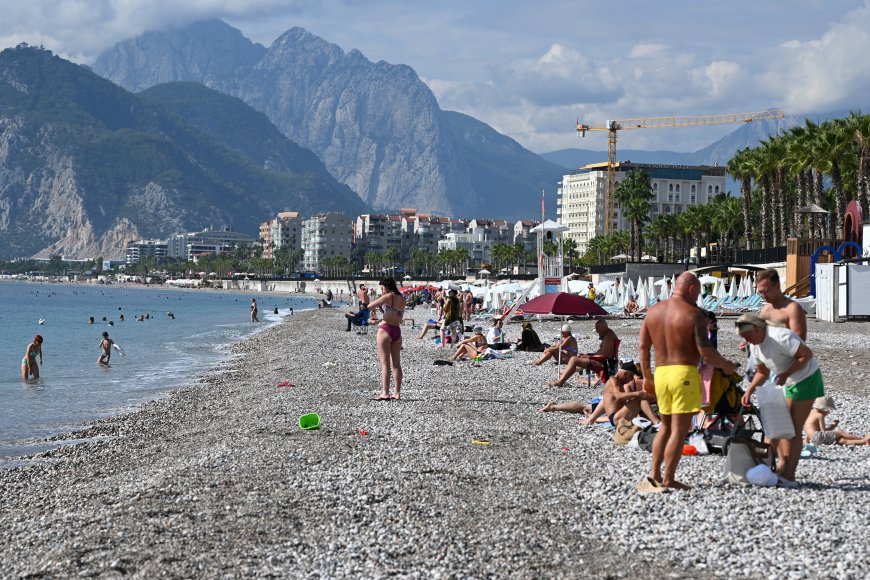 Antalya'da sağanak bitti, Konyaaltı sahili canlandı! Köpeği Atom ile denize girdi